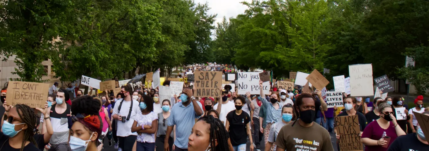 People marching with signs at a Charlotte NAACP protest on June 8th, 2020. Photo by Leslie Cross on Unsplash.