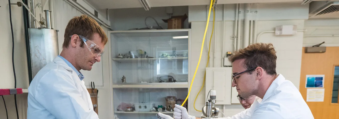 Professor Barnes works with students in his lab
