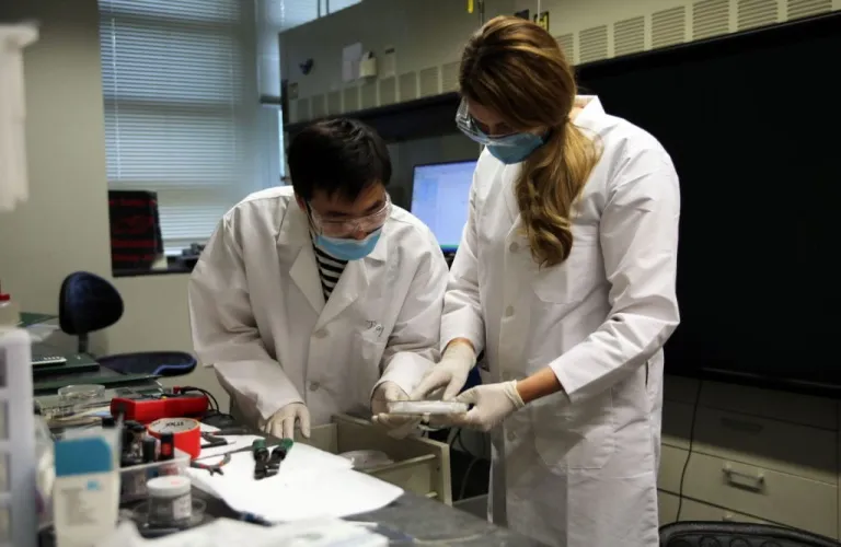 Daugs (right) and graduate student Jiang Luo conduct scientific research in the lab of Bryce Sadtler, assistant professor of chemistry.