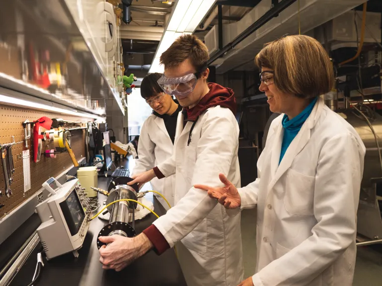 students and professor working in lab