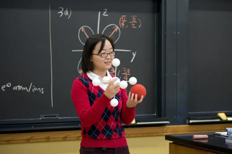 professor holding atom models