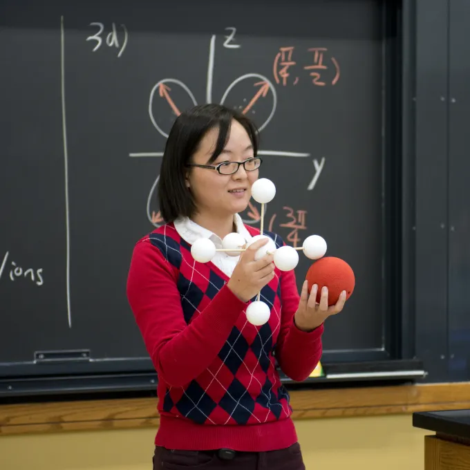 professor holding atom models